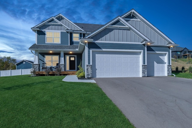 craftsman house with covered porch, a garage, and a yard