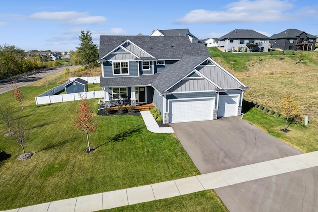 craftsman inspired home featuring a porch, a garage, and a front lawn