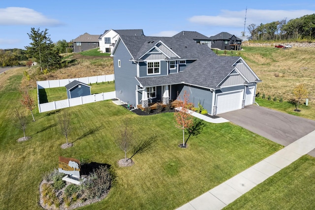 view of front of home featuring a garage, covered porch, and a front yard