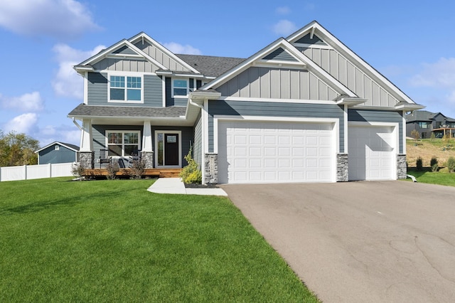 craftsman-style home featuring covered porch, a garage, and a front lawn