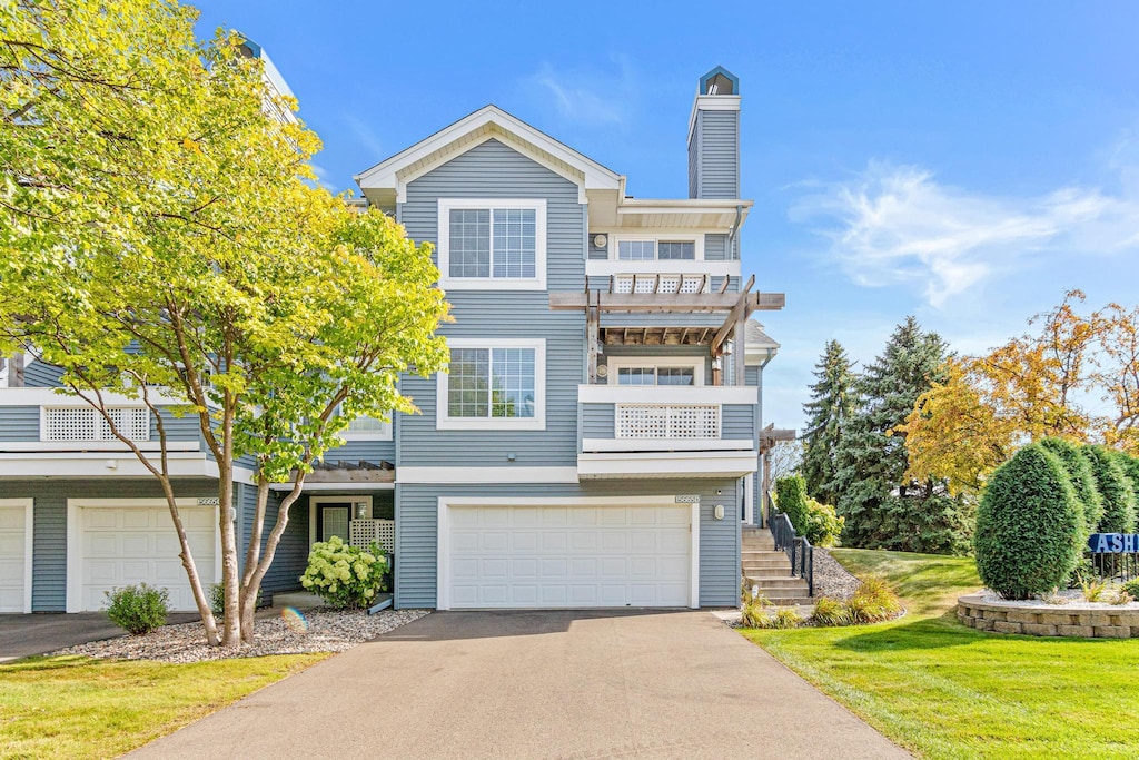 view of front of house with a balcony, a garage, and a front yard