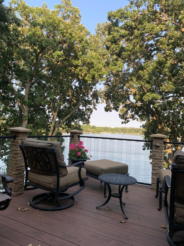 wooden terrace featuring a grill and a water view