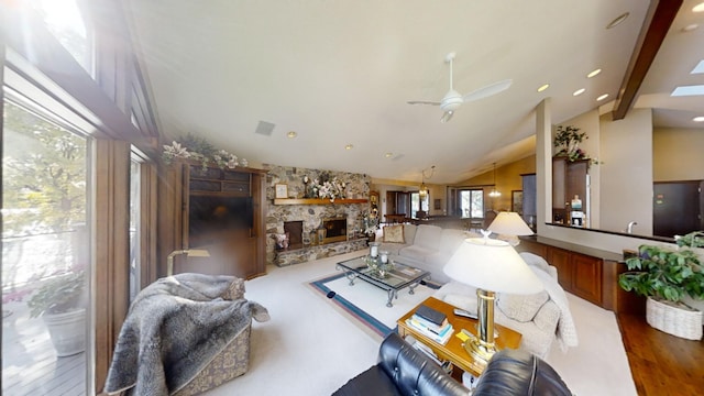 living room with a stone fireplace, ceiling fan, high vaulted ceiling, and dark wood-type flooring