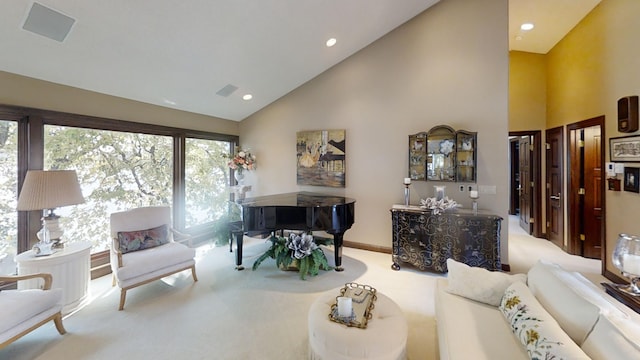 carpeted living room with high vaulted ceiling