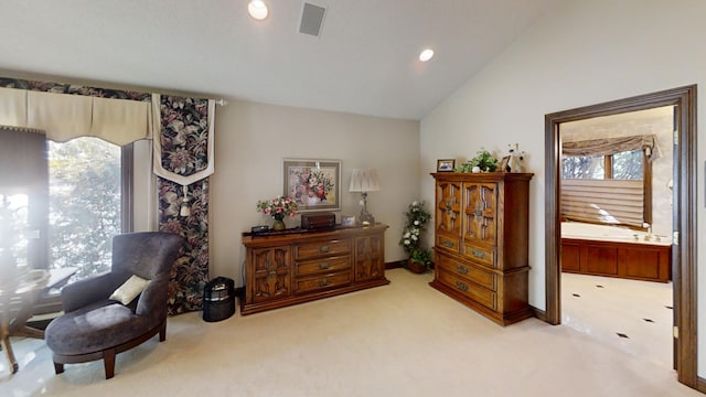 living area featuring light colored carpet and vaulted ceiling