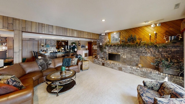 carpeted living room featuring wooden walls and a fireplace