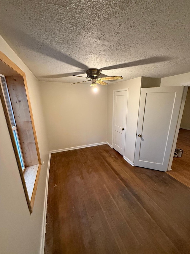 unfurnished bedroom with ceiling fan, dark hardwood / wood-style flooring, and a textured ceiling