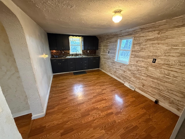 unfurnished living room with wood-type flooring, a textured ceiling, and sink