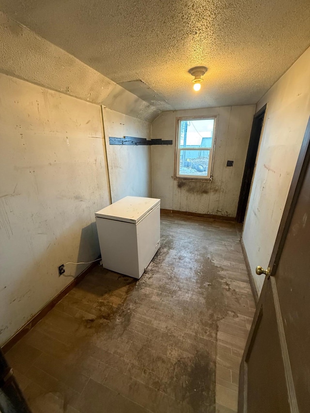 bathroom with a textured ceiling and vaulted ceiling