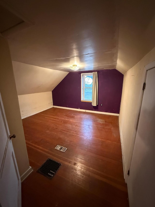 additional living space featuring hardwood / wood-style flooring and vaulted ceiling