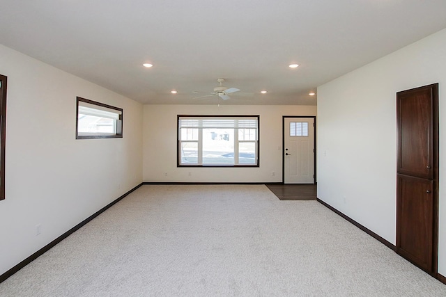 carpeted spare room featuring ceiling fan