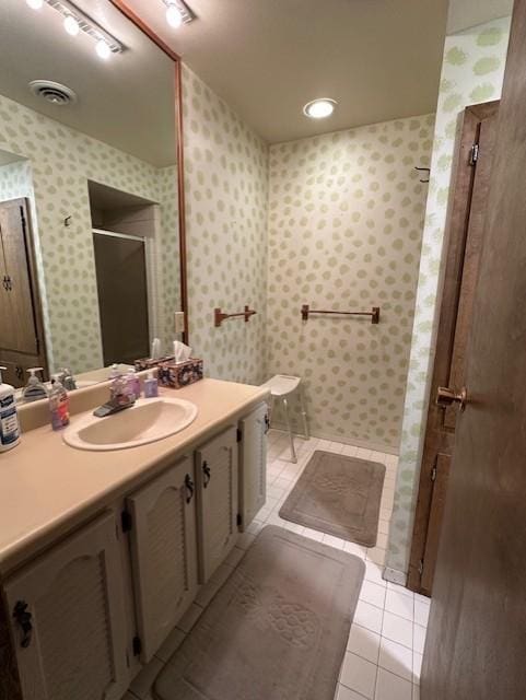 bathroom with tile patterned floors, vanity, and walk in shower