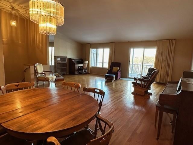 dining area with wood-type flooring and an inviting chandelier