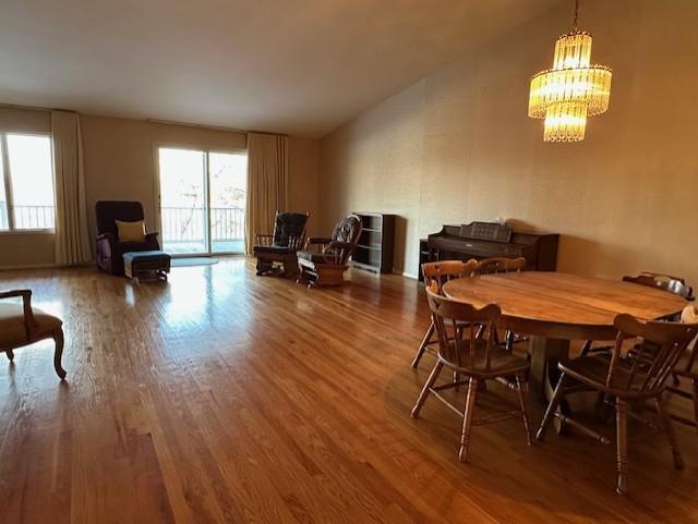 dining area with hardwood / wood-style flooring and a notable chandelier