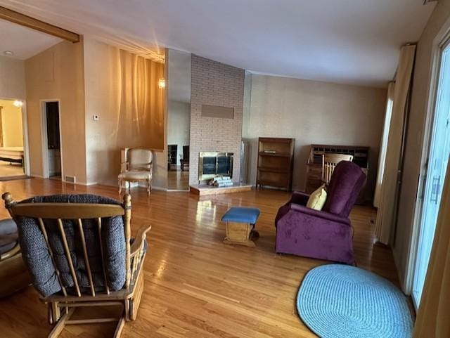 living area featuring a fireplace, light hardwood / wood-style floors, and lofted ceiling