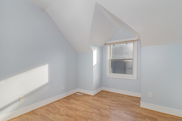 bonus room featuring vaulted ceiling and light wood-type flooring