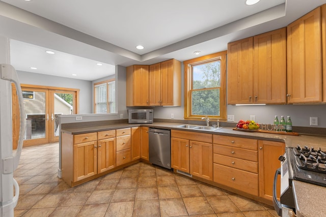 1096 14th Ave SE, Minneapolis, MN 55414 - kitchen featuring stainless steel appliances, a peninsula, recessed lighting, brown cabinetry, and dark countertops