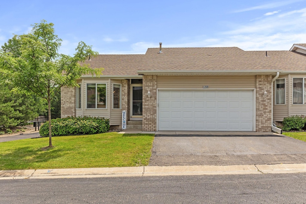 single story home with a front yard and a garage