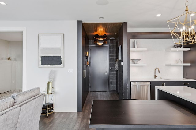 kitchen featuring stainless steel dishwasher, dark wood-type flooring, sink, decorative light fixtures, and a notable chandelier