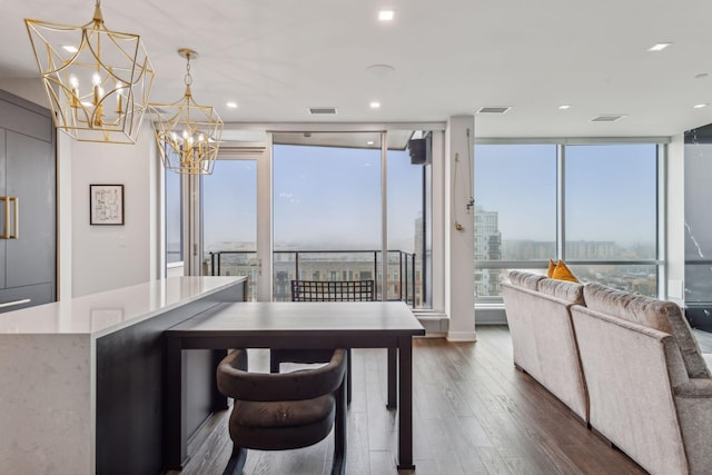 dining space featuring dark hardwood / wood-style flooring, a wall of windows, and a notable chandelier