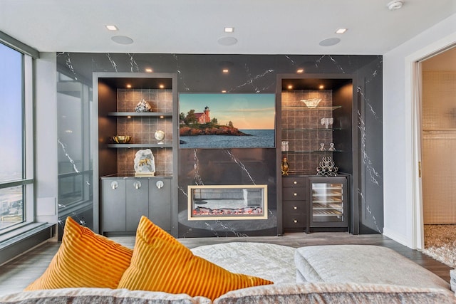 bar with a fireplace, hardwood / wood-style flooring, wine cooler, and a wall of windows