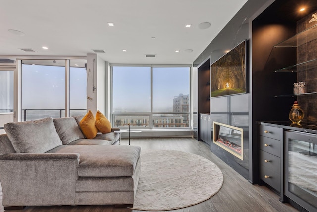 living room with bar, expansive windows, beverage cooler, and light hardwood / wood-style flooring