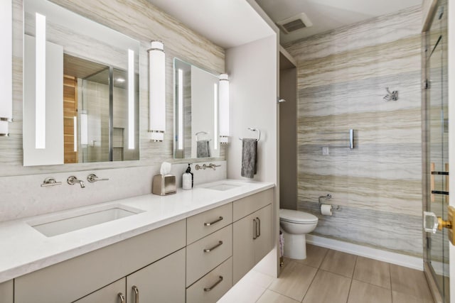 bathroom featuring a shower with door, vanity, tile walls, and toilet