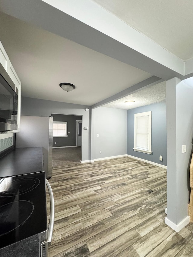 interior space with stainless steel refrigerator and hardwood / wood-style flooring