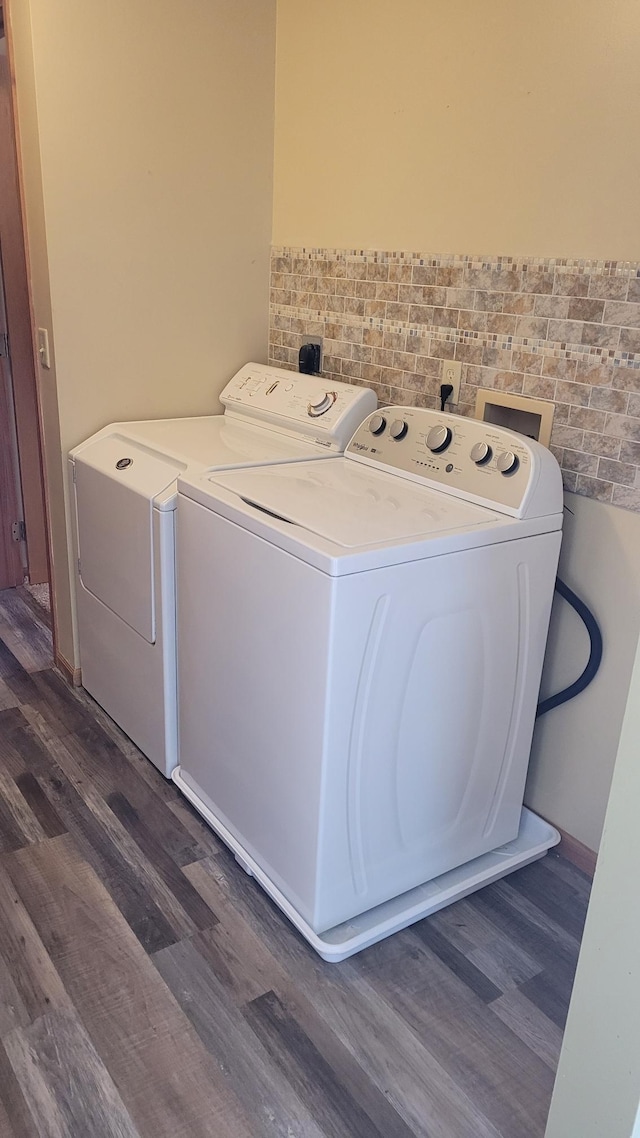 clothes washing area featuring independent washer and dryer, dark hardwood / wood-style flooring, and tile walls