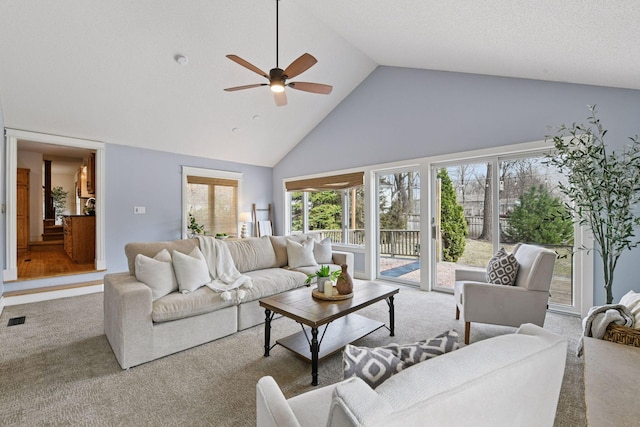 living room featuring visible vents, high vaulted ceiling, carpet flooring, and a ceiling fan