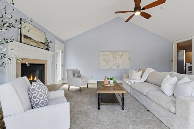 carpeted living room featuring baseboards, lofted ceiling, ceiling fan, and a glass covered fireplace