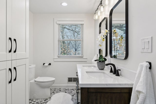 full bathroom featuring toilet, a sink, and a healthy amount of sunlight