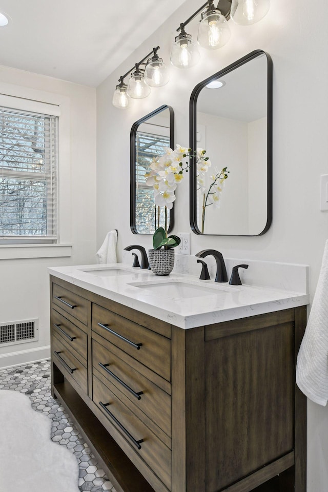 full bathroom featuring tile patterned floors, double vanity, a sink, and visible vents