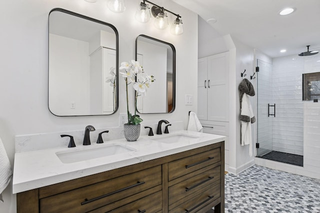 bathroom featuring double vanity, a sink, a stall shower, and recessed lighting