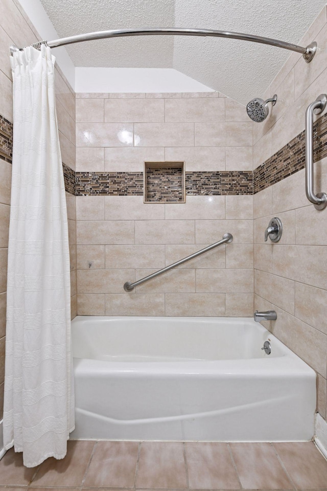 full bath with a textured ceiling, shower / bath combo with shower curtain, and tile patterned flooring