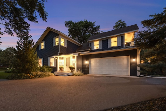 traditional-style house featuring a garage and aphalt driveway