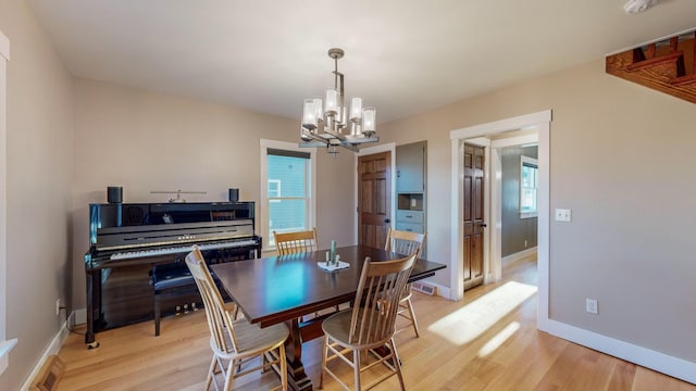 dining room featuring light hardwood / wood-style floors, a wealth of natural light, and a chandelier