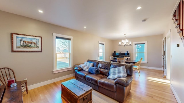 living room with an inviting chandelier and light hardwood / wood-style flooring