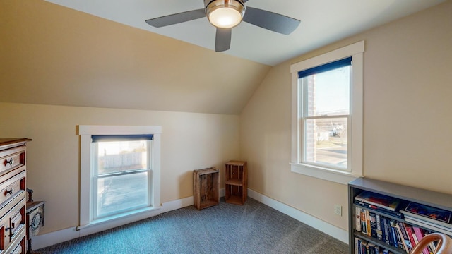 additional living space featuring dark colored carpet, plenty of natural light, ceiling fan, and lofted ceiling