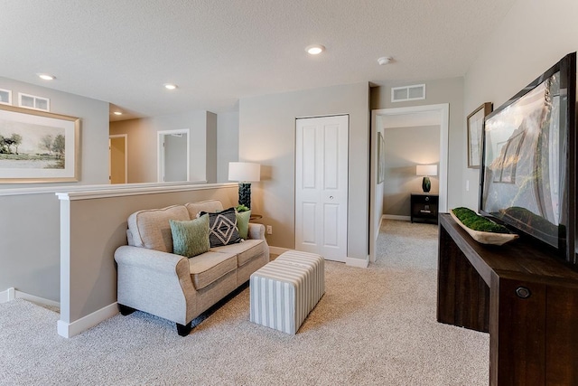 sitting room featuring a textured ceiling and light carpet