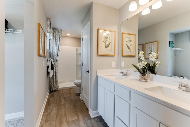 bathroom featuring walk in shower, toilet, vanity, and hardwood / wood-style flooring