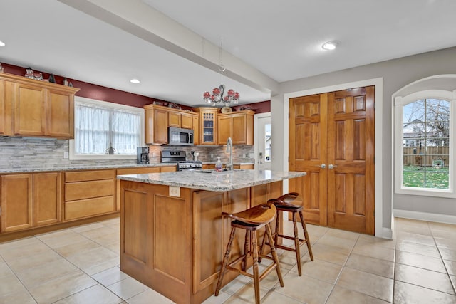 kitchen with tasteful backsplash, a center island, a healthy amount of sunlight, and appliances with stainless steel finishes