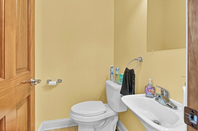 bathroom featuring tile patterned flooring, toilet, and sink