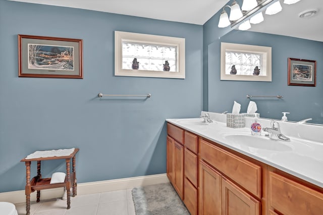 bathroom with tile patterned flooring, vanity, and a healthy amount of sunlight