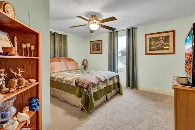 bedroom featuring ceiling fan, light carpet, and a textured ceiling