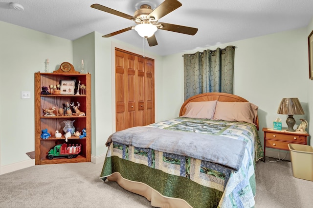 carpeted bedroom featuring ceiling fan, a closet, and a textured ceiling