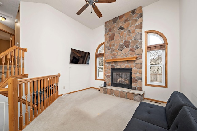 carpeted living room with a textured ceiling, ceiling fan, a fireplace, and high vaulted ceiling