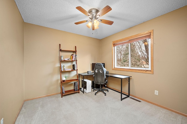 carpeted office space featuring a textured ceiling and ceiling fan