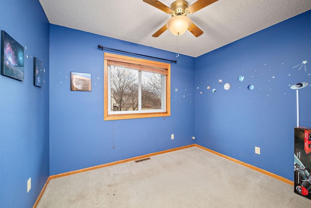 carpeted empty room featuring a textured ceiling and ceiling fan