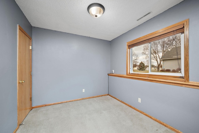 carpeted spare room featuring a textured ceiling